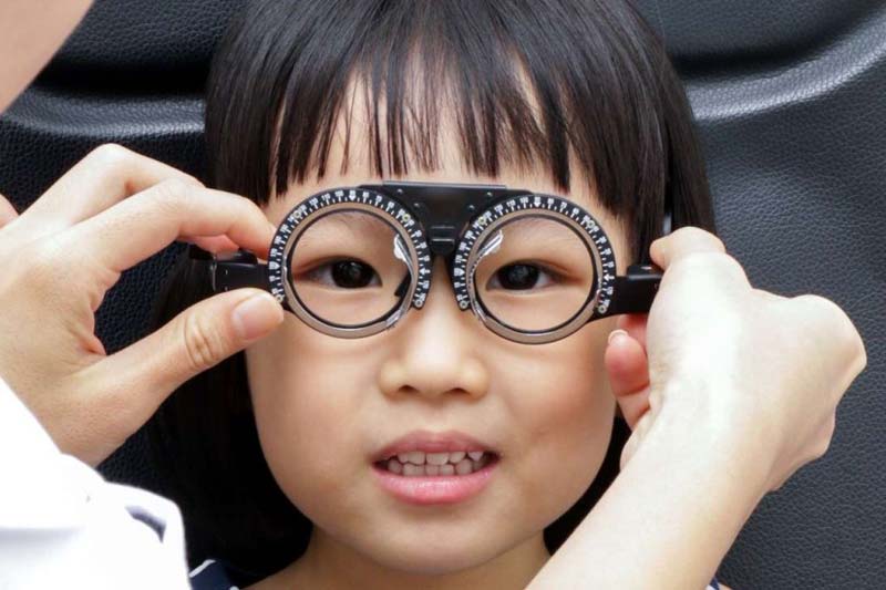 A girl is having her eyes checked.