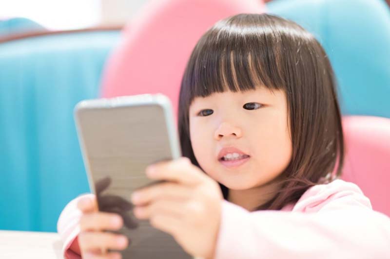 A toddler using a smartphone.